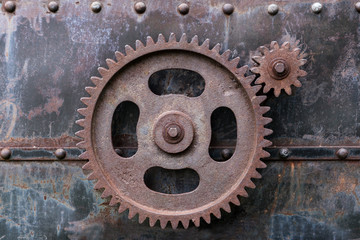 Fototapeta na wymiar Rustic gearwheels on metal rusty background