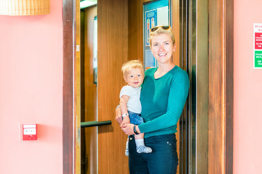 Smiling mother and baby boy entering an elevator
