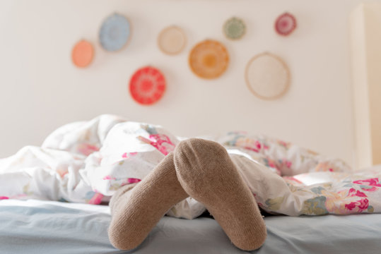 Female feet in warm wool socks, Woman Sleeping and Relaxing in bed