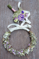 Flower head band and little bouquet on wooden surface