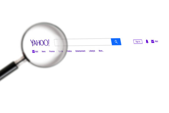 Yahoo website under a magnifying glass. Yahoo is tech company, leader in search engine service and information technology web portals. Moscow, Russia - November 28, 2018