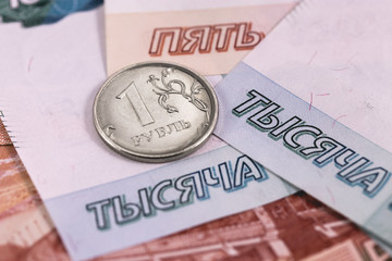 One Russian ruble coin and banknotes