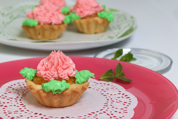 Basket cake decorated with cream of different colors. Stuffing from jam. Decorated with mint leaves.