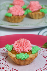 Basket cakes decorated with cream of different colors. Stuffing from jam.