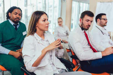 Group of happy doctors on seminar in lecture hall at hospital