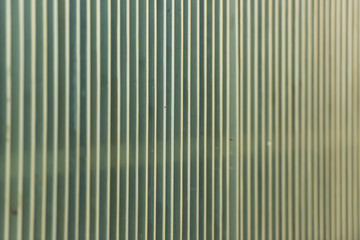 Metal corrugated fence. The texture of the corrugated metal surface. Fence of iron.