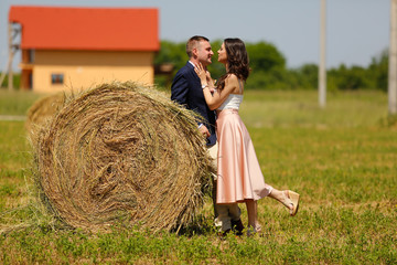 Beautiful engagement couple posing near hay