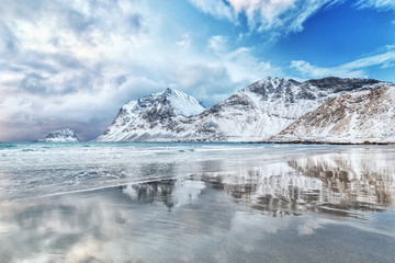 Fototapeta premium Captivating arctic scenery of Haukland beach in Norway on Lofoten islands - iconic travel destination of nature lovers. Majestic scene on northern arctic beach on March. Norwegian sea coastline.