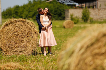 Beautiful engagement couple posing near hay