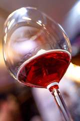 Glass of red wine detail with blurry background closeup