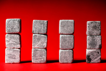 stones for whiskey on a red background, bulk texture on stones.
