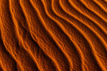 orange toned sand background with a wavy pattern.