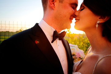Bride and groom posing in sun