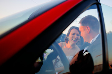 Couple watching the sunset in a convertible car.