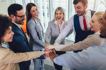 Large business team showing unity with their hands together. Selective focus