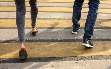 People in the city cross the road at a pedestrian crossing