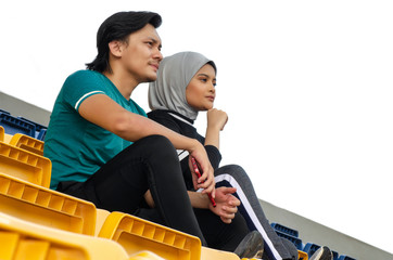 portrait of young sportsman and woman sitting and talking each other