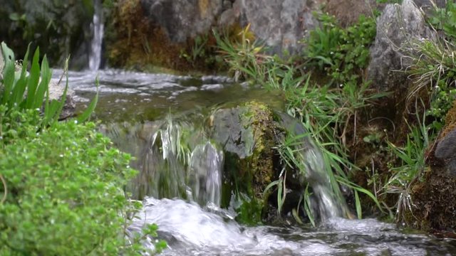 Slow motion Flowing water stream, water drops and reflection