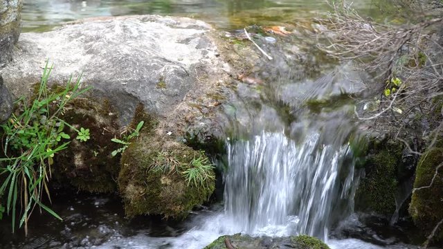 Flowing water stream, water drops and reflection