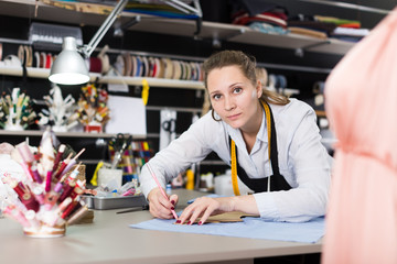 Woman  tailor working with marker for modeling clothes at workshop