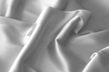Obraz na płótnie Canvas Rippled white silk fabric satin cloth waves background