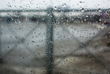 texture of bokeh drops on glass in front of urban park landscape