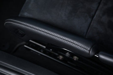 Close up of contrast stitching on black leather car seat
