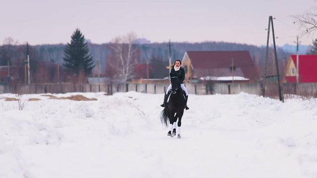 A woman riding a horse in a village