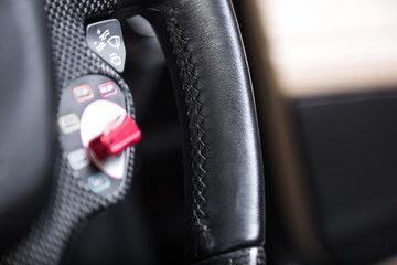Close up of stitching on black leather car steering wheel