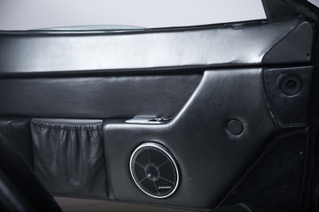 Close up of speaker in black leather classic car interior