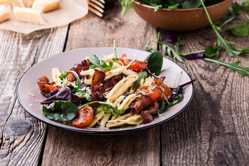 Handmade fusilli pasta with pancetta, roasted cherry tomatoes and fresh green vegetables