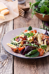 Handmade fusilli pasta with pancetta, roasted cherry tomatoes and fresh green vegetables