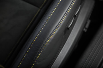 Yellow contrast stitching on black leather car seat