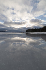 Sky reflection from wet ice surface at lake
