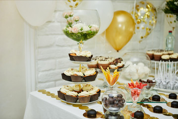 candy bar decorated by delicious sweet buffet with cupcakes and other desserts/candies,happy birthday concept
