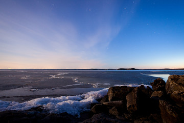 Fototapeta premium Partially melting ice in lake at night