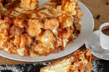 Cake profiteroles with caramel glaze, mascarpone and chocolate. Closeup