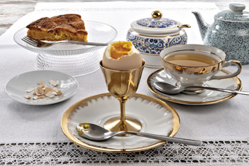 uovo bollito sgusciato rotto con torta di mele e tazza di the altra veduta