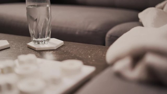 Girl grabbing Roku TV remote control from coffee table.