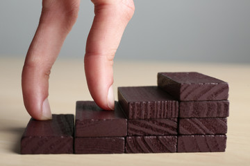 Human hand imitating walking upstairs. Concept of career growth