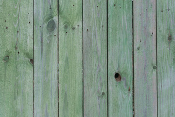 Old wooden green faded fence background and texture