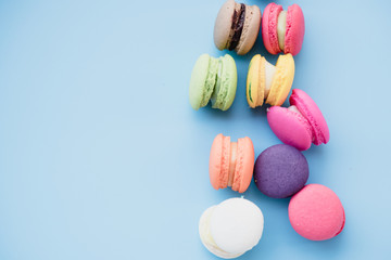 Colorful macaroons cookies cake on blue background and free space.Different color macarons dessert sweet taste in the coffee shop.Difference color concept