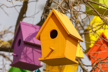 Yellow birdhouse on tree