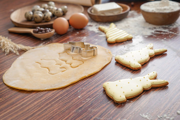 Cooking of tasty Easter cookies on wooden table