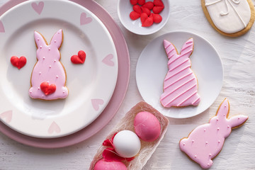 Tasty Easter cookies with eggs on white table