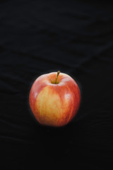 A single apple on a black background