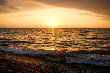 Golden, Fiery sunset on the Black Sea, on the beach. Coast, stones, waves, sun, beautiful sky, clouds. August, Batumi, Georgia. Water, ease, game.