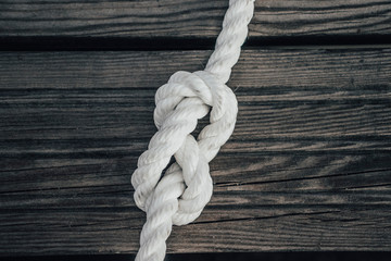 Ship rope knot on wooden background
