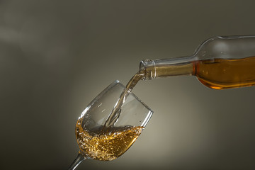 Pouring of wine into glass on color background