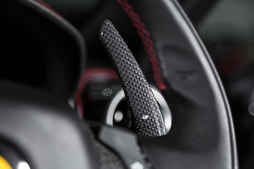 Fototapeta na wymiar Carbon fibre paddle shifting in sports car steering wheel